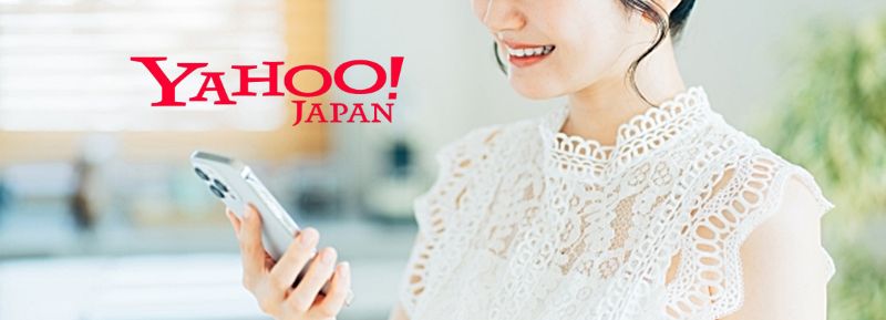 白いレースのブラウス姿の若い女性がスマホを笑顔で見つめ、左上に赤い YAHOO! JAPAN ロゴが並ぶバナー画像